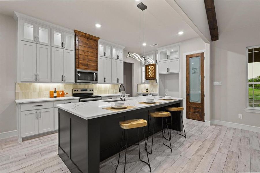 Kitchen with glass insert cabinets, backsplash, white cabinetry, a breakfast bar, and recessed lighting