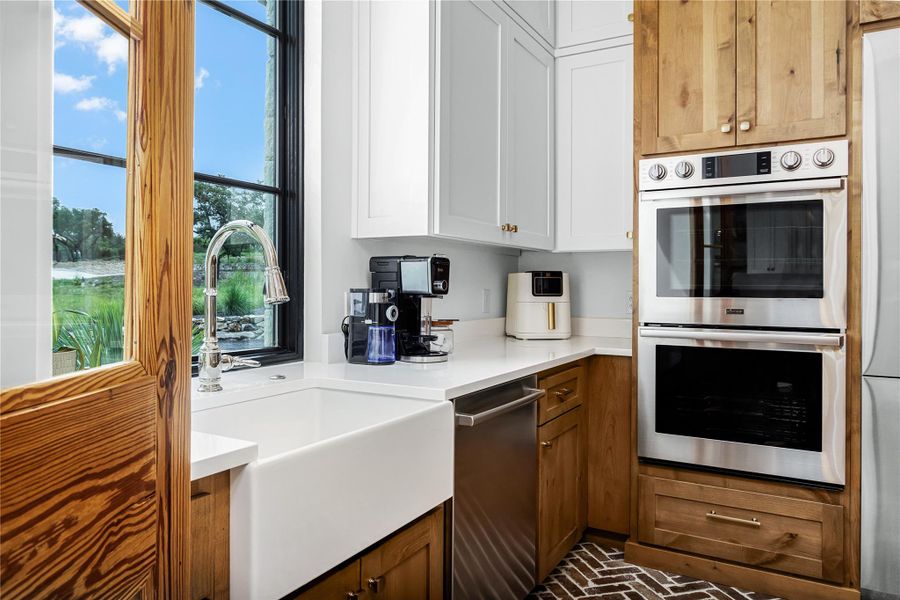 Kitchen featuring stainless steel appliances, sink, and white cabinets