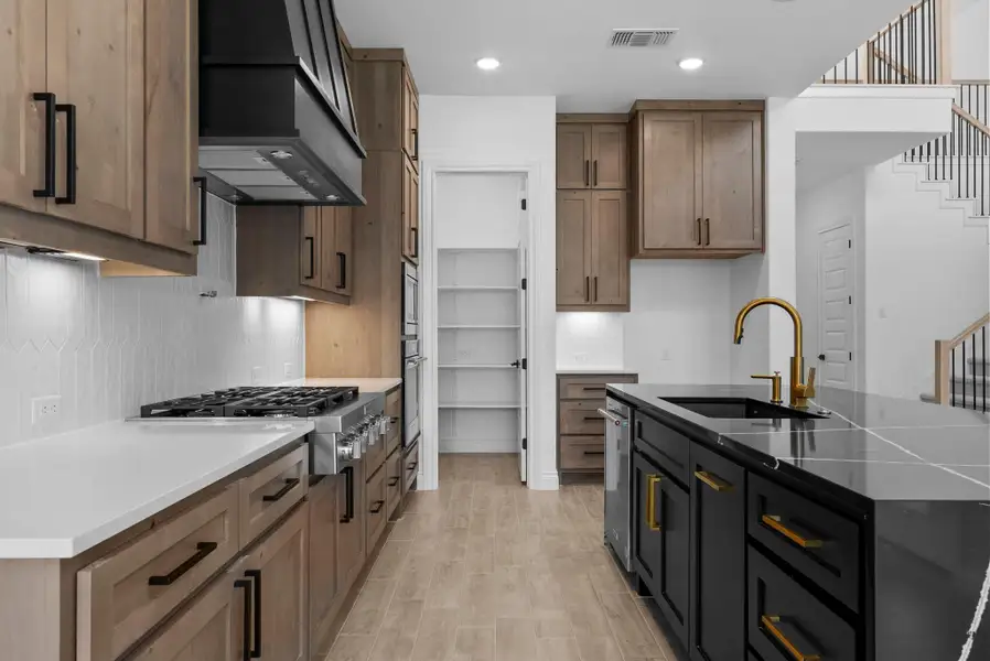 Gourmet kitchen with ample storage, designer finishes, and walk-in pantry.