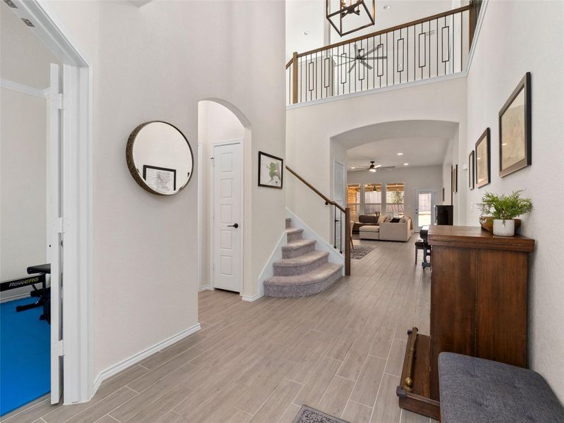 Foyer entrance with arched walkways,  and tile floors, ceiling fan
