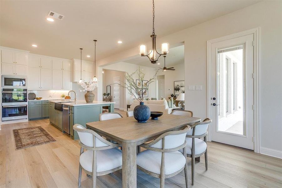 Dining area featuring sink, light hardwood / wood-style flooring, and a healthy amount of sunlight