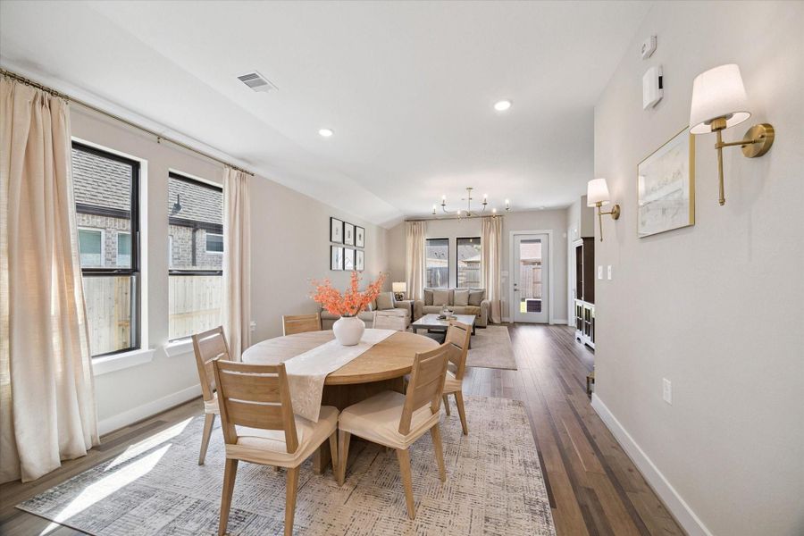Sunlit dining area framed by large windows and soft drapery—offering the perfect spot for everyday meals or cozy gatherings.