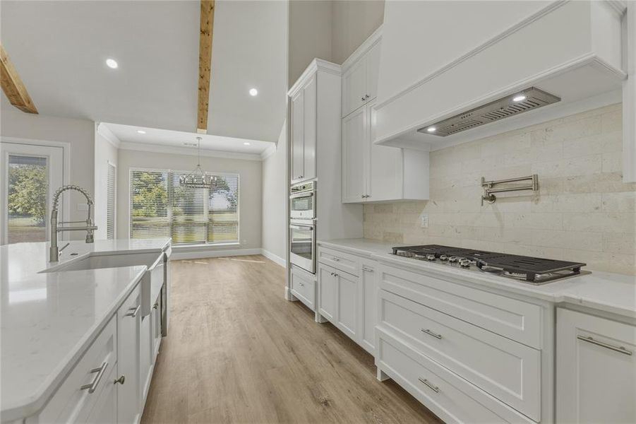View of dining area and gas cook top with pot filler. View of dining area and gas cook top with pot filler.