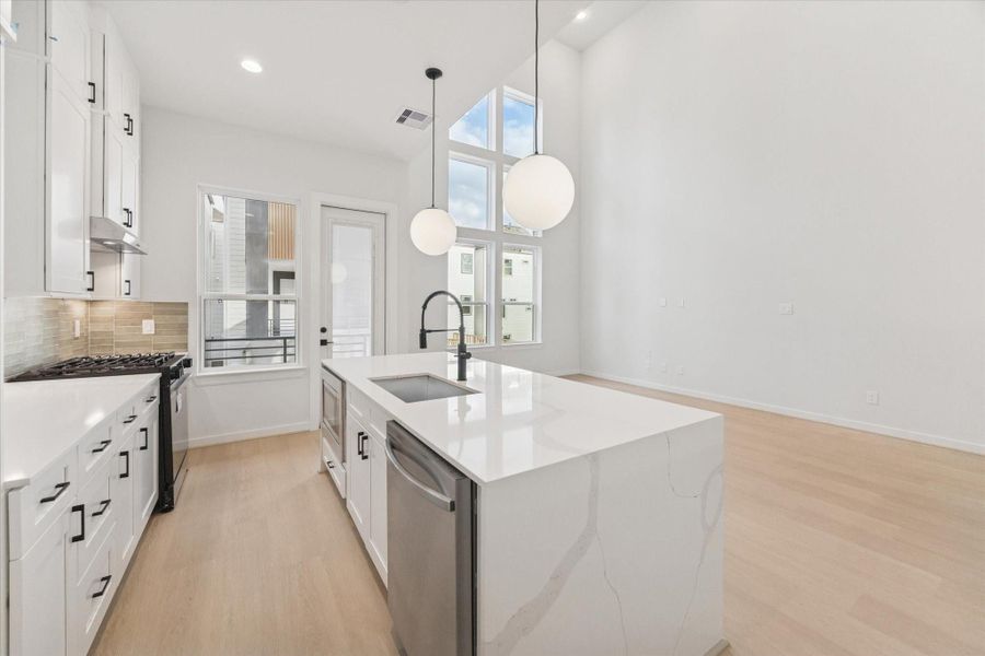 The trio of stacked windows floods the room with natural light, enhancing the open, airy feel.