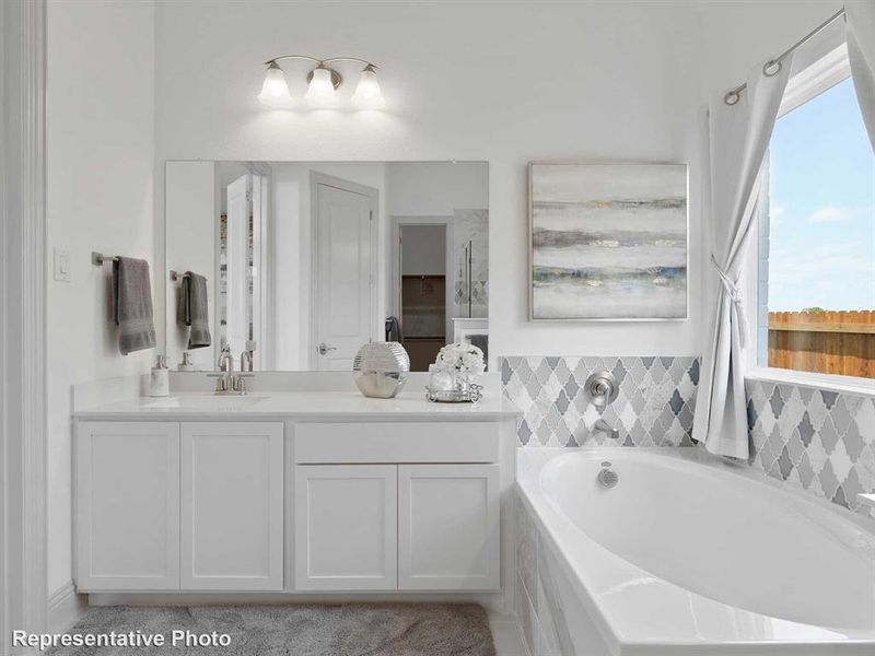 The bathroom features a double vanity with white cabinetry and a light-colored countertop
