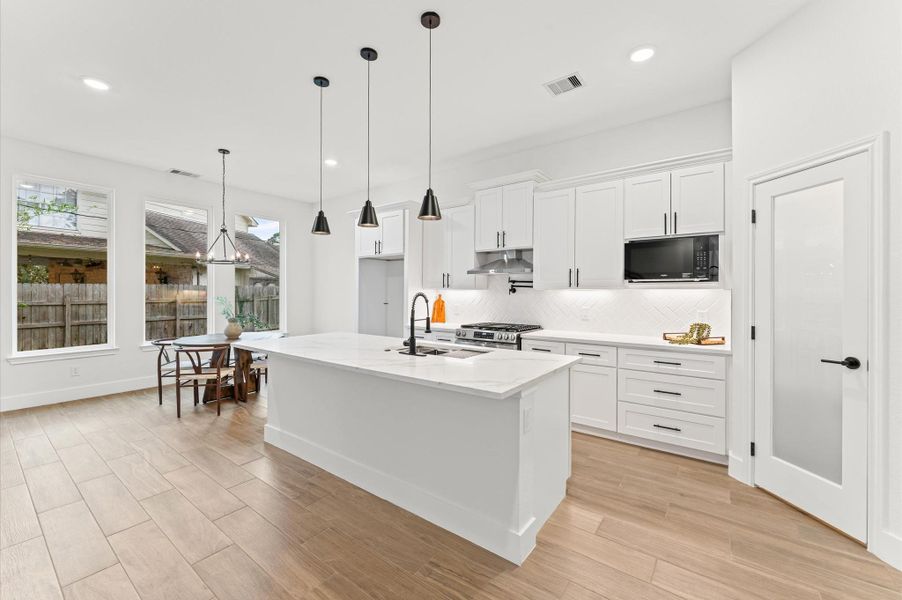 Gourmet kitchen with soft-close drawers, stainless steel appliances, pot filler, and designer backsplash. The large island provides extra seating and prep space. Gourmet kitchen with soft-close drawers, stainless steel appliances, pot filler, and designer backsplash. The large island provides extra seating and prep space.