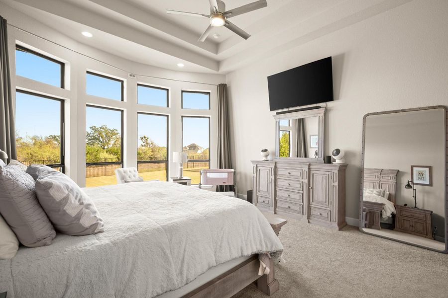 Bedroom with light carpet, a high ceiling, a ceiling fan, and recessed lighting Bedroom with light carpet, a high ceiling, a ceiling fan, and recessed lighting