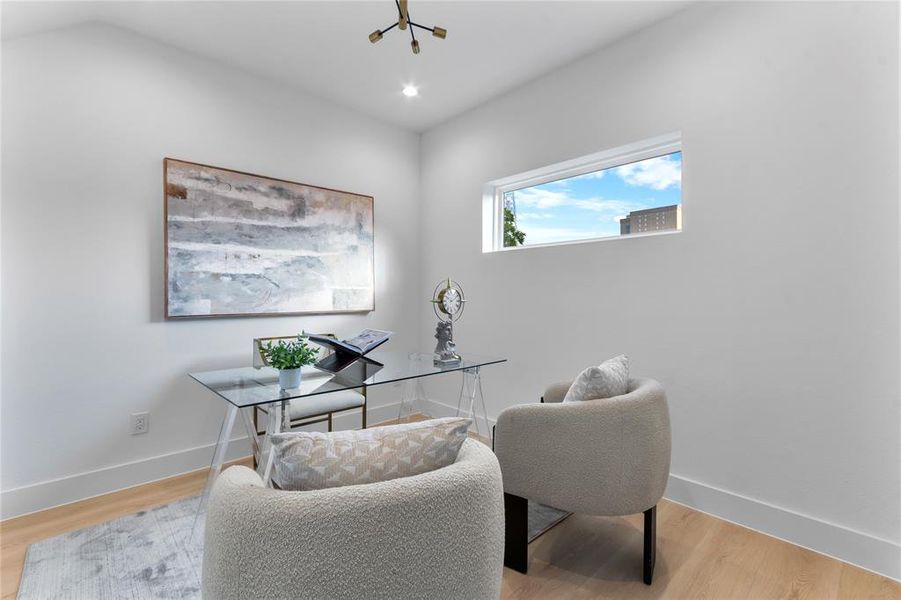 Dedicated room featuring light wood-finish flooring, a contemporary horizontal window, and a modern light fixture Dedicated room featuring light wood-finish flooring, a contemporary horizontal window, and a modern light fixture
