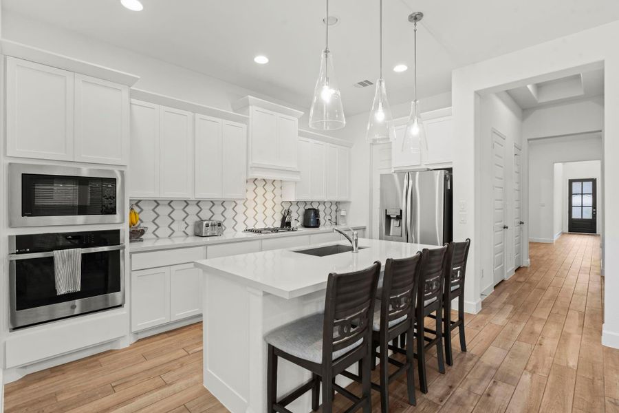 Gourmet chefs and home cooks will love this spacious kitchen, featuring wood-look tile flooring, breakfast bar seating, sleek quartz countertops, and stainless steel appliances.  An abundance of recessed lighting adds to the home’s inviting ambiance.  Plenty of room to create, gather, and enjoy!