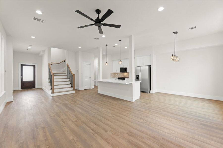 This spacious, open-concept living area features modern finishes, and ample natural light. The kitchen includes stainless steel appliances and a large island, perfect for entertaining.