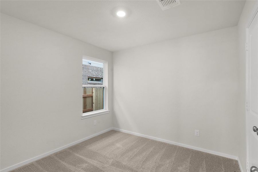 Unfurnished room featuring baseboards and light carpet