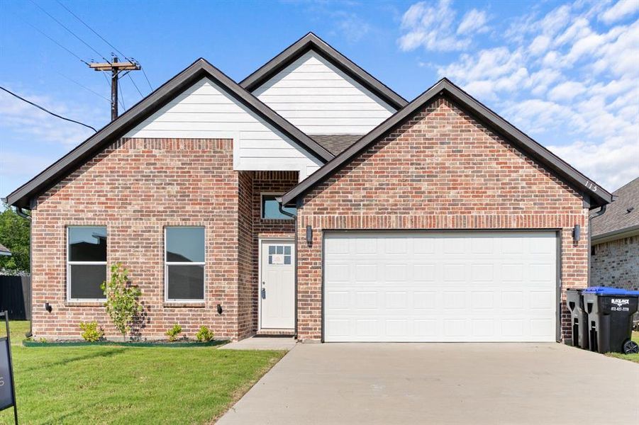 View of front facade with concrete driveway, brick siding, an attached garage, and a front yard View of front facade with concrete driveway, brick siding, an attached garage, and a front yard