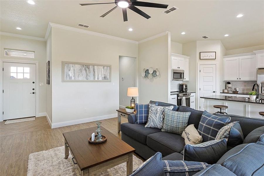 Open-concept living space featuring wood-finish flooring, recessed lighting, and a ceiling fan