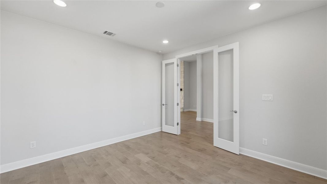 Empty room with light wood-type flooring, recessed lighting, and french doors Empty room with light wood-type flooring, recessed lighting, and french doors