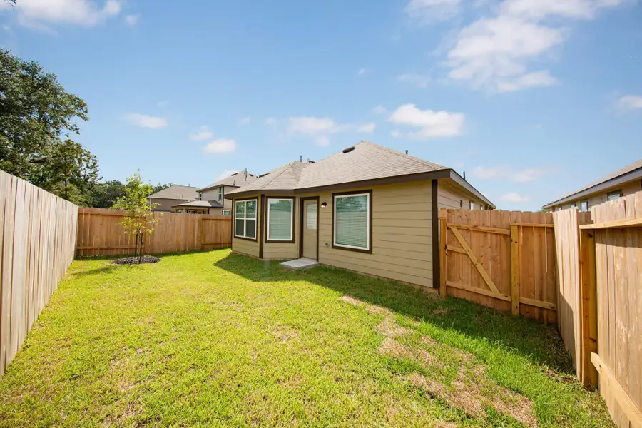 Front exterior of a new home in Mackenzie Creek, Conroe, TX, highlighting curb appeal (Image 1).