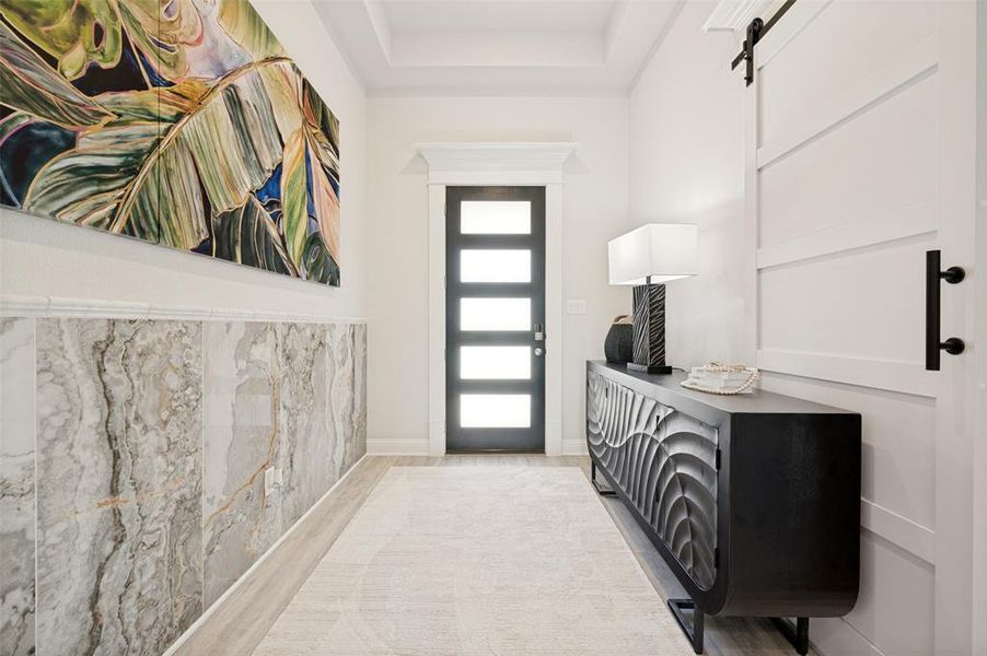 A dramatic foyer welcomes you with custom marble-inspired wall treatments, elevated architectural details, and a contemporary glass-panel front door. This thoughtfully curated space blends modern elegance with timeless design, creating a warm and sophisticated introduction to the home. A dramatic foyer welcomes you with custom marble-inspired wall treatments, elevated architectural details, and a contemporary glass-panel front door. This thoughtfully curated space blends modern elegance with timeless design, creating a warm and sophisticated introduction to the home.