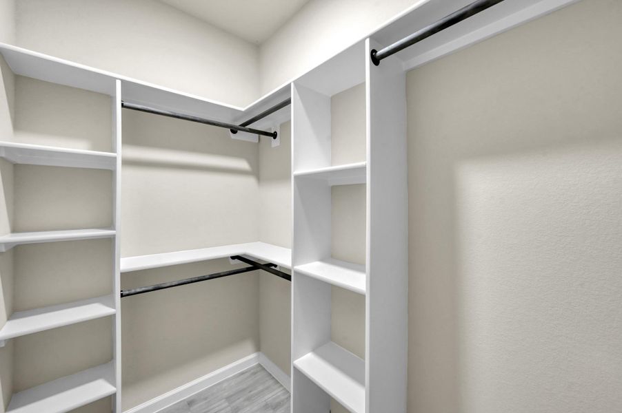 Organization made easy! This generous walk-in closet features wrap-around custom built-in shelving and dual hanging rods, providing ample storage while maintaining the home’s clean, modern aesthetic.