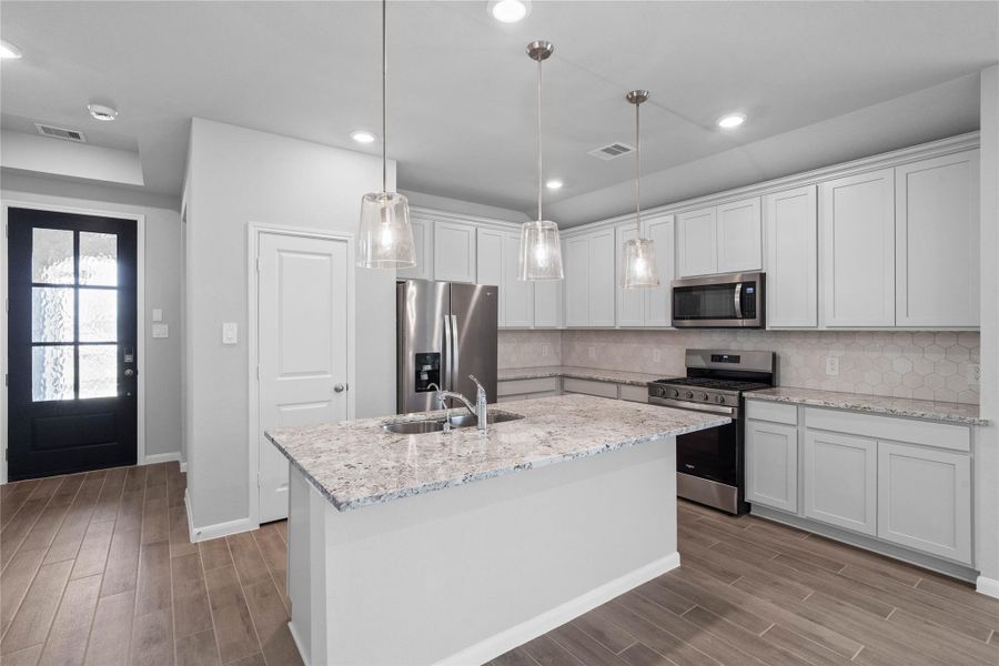 The extended granite countertop creates a convenient breakfast bar, providing a casual and inviting space where stools can be added for quick meals or long conversations.