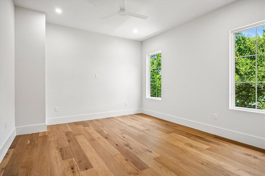 Secondary bedroom, hardwood floors, multi-window views Secondary bedroom, hardwood floors, multi-window views