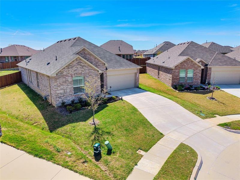 View of front facade featuring roof with shingles, brick siding, an attached garage, concrete driveway, and a front yard View of front facade featuring roof with shingles, brick siding, an attached garage, concrete driveway, and a front yard