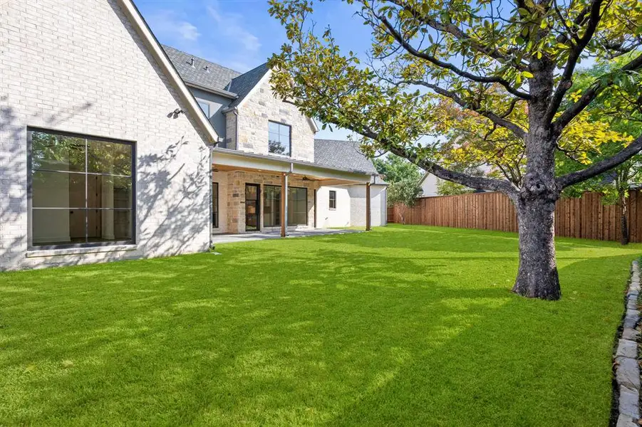 Back of property with a patio, brick siding, and stone siding Back of property with a patio, brick siding, and stone siding