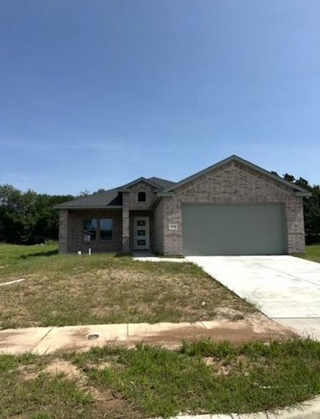 View of front of home with an attached garage, concrete driveway, brick siding, and a front lawn View of front of home with an attached garage, concrete driveway, brick siding, and a front lawn