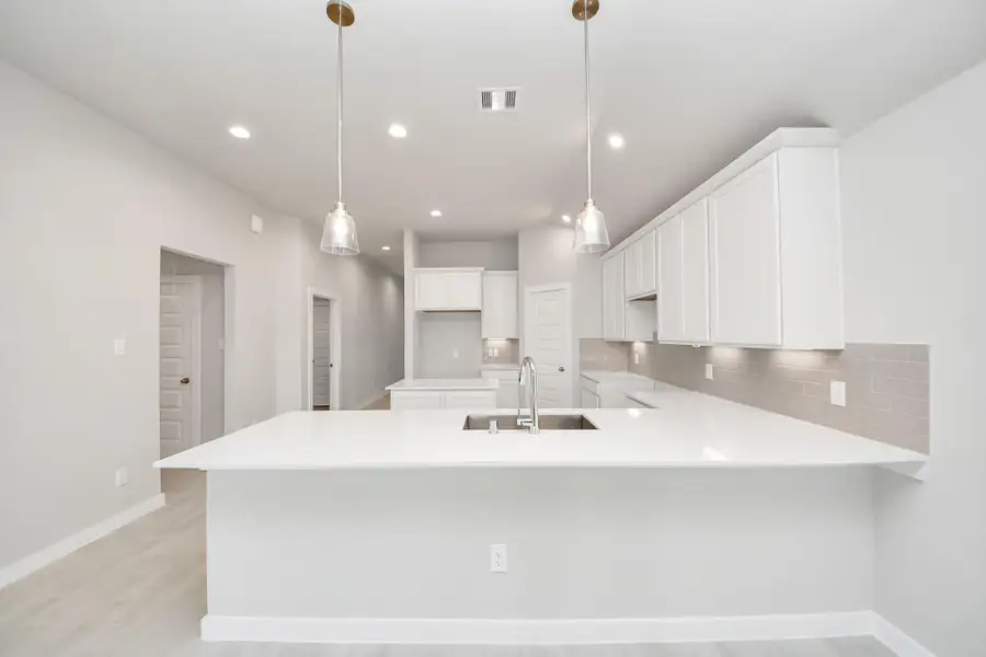 Discover another perspective of this stunning kitchen, generously appointed with an abundance of counter space. Sample photo of completed home with similar floor plan. Actual colors and selections may vary. Discover another perspective of this stunning kitchen, generously appointed with an abundance of counter space. Sample photo of completed home with similar floor plan. Actual colors and selections may vary.