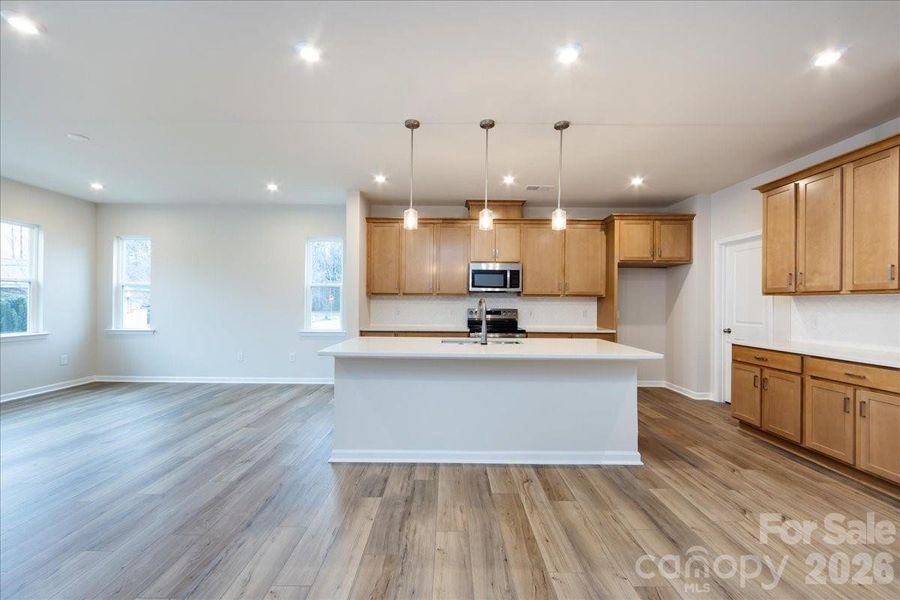 Chef's kitchen with Direct Vent, Stained Cabinetry, Quartz Cabinetry, and Herringbone Backsplash