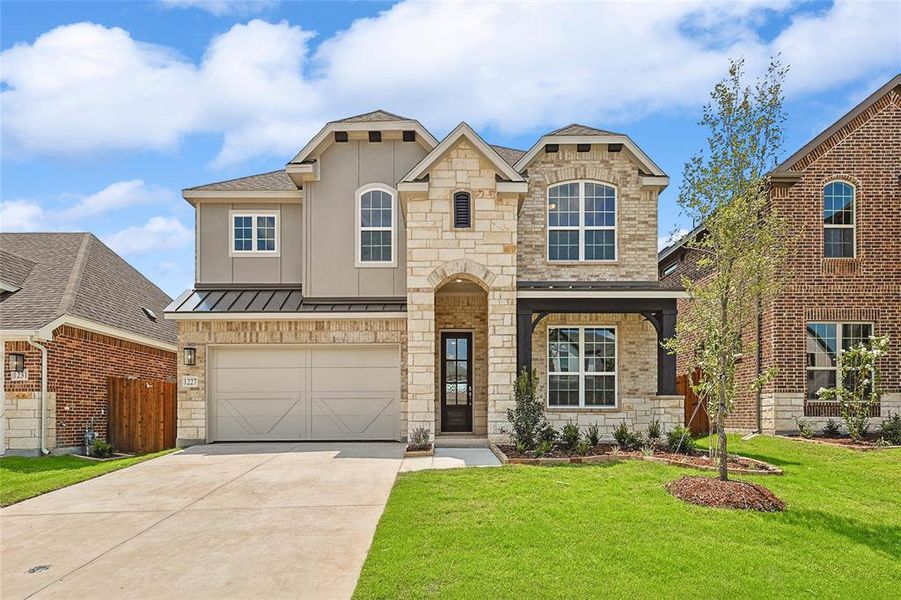 View of front of home with a garage and a front yard