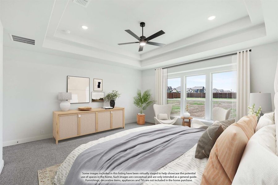 Bedroom with tray ceiling, ceiling fan, large windows, and neutral carpet flooring