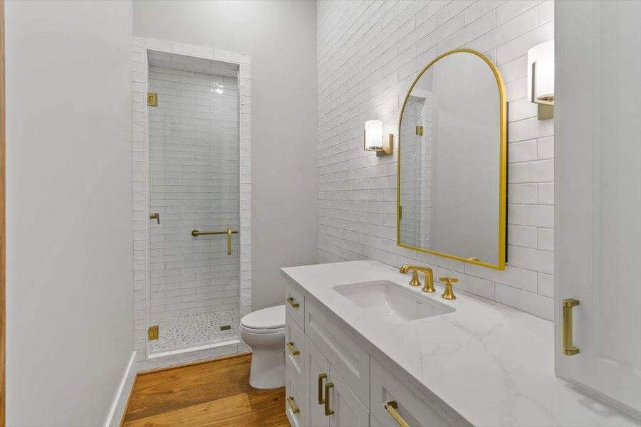 Guest room bath...featurea a medicine cabinet, sconces, tiled accent wall and walk in shower