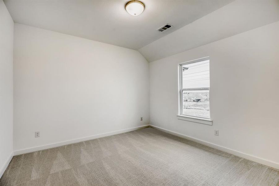 White walls with a single window and light-colored carpeting