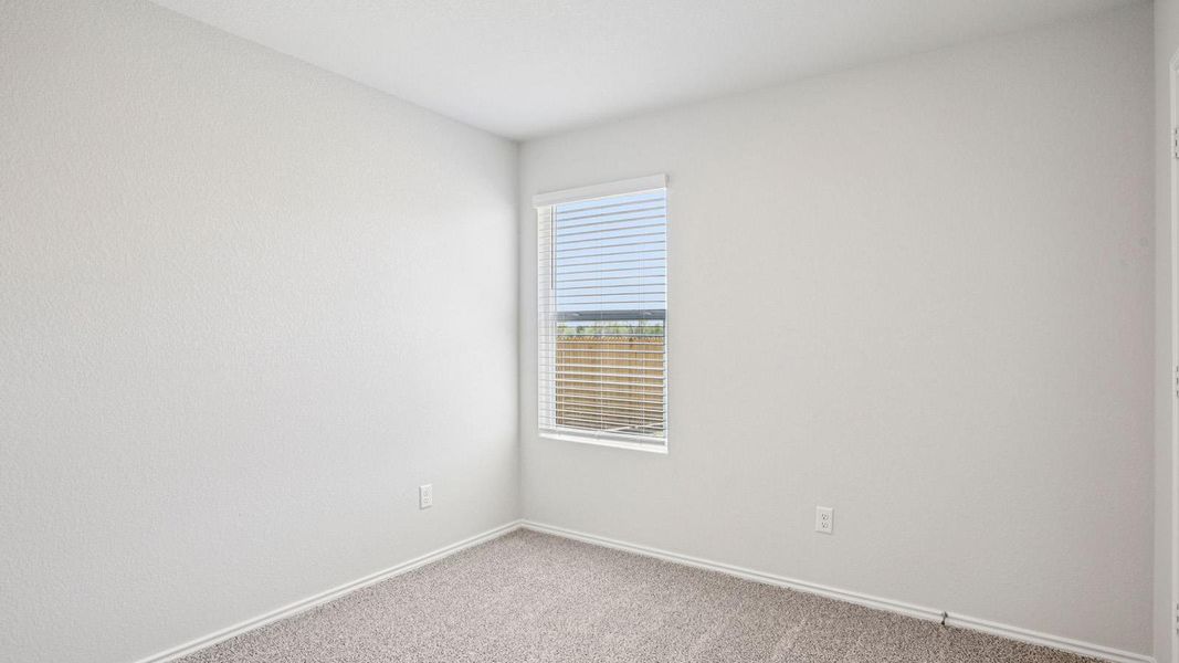 Bright room featuring a single window with blinds, light-toned walls, and neutral carpeting Bright room featuring a single window with blinds, light-toned walls, and neutral carpeting