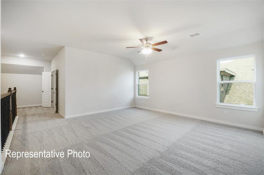 Spare room featuring light colored carpet, ceiling fan, and lofted ceiling