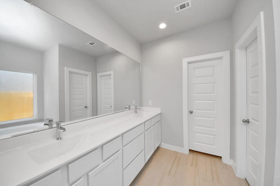 Escape to a spa-like oasis in this primary bathroom. Enjoy a walk-in shower with tile surround, a separate garden tub with custom detailing, and an elegant vanity featuring light countertops, modern hardware, and beautiful recessed lights. Experience luxury and relaxation in every detail. Sample photo of completed home with similar floor plan. Actual colors and selections may vary. Escape to a spa-like oasis in this primary bathroom. Enjoy a walk-in shower with tile surround, a separate garden tub with custom detailing, and an elegant vanity featuring light countertops, modern hardware, and beautiful recessed lights. Experience luxury and relaxation in every detail. Sample photo of completed home with similar floor plan. Actual colors and selections may vary.