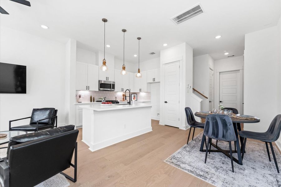 Experience effortless flow and modern elegance in this open-concept kitchen, living, and dining space. Anchored by a spacious island with bar seating, the kitchen boasts sleek cabinetry, stainless steel appliances, and quartz countertops. The adjoining dining area offers ample room for gatherings, while the sunlit living room invites relaxation with its cozy layout and large windows. Perfect for entertaining or everyday living, this seamless layout blends style and functionality in one stunning space.