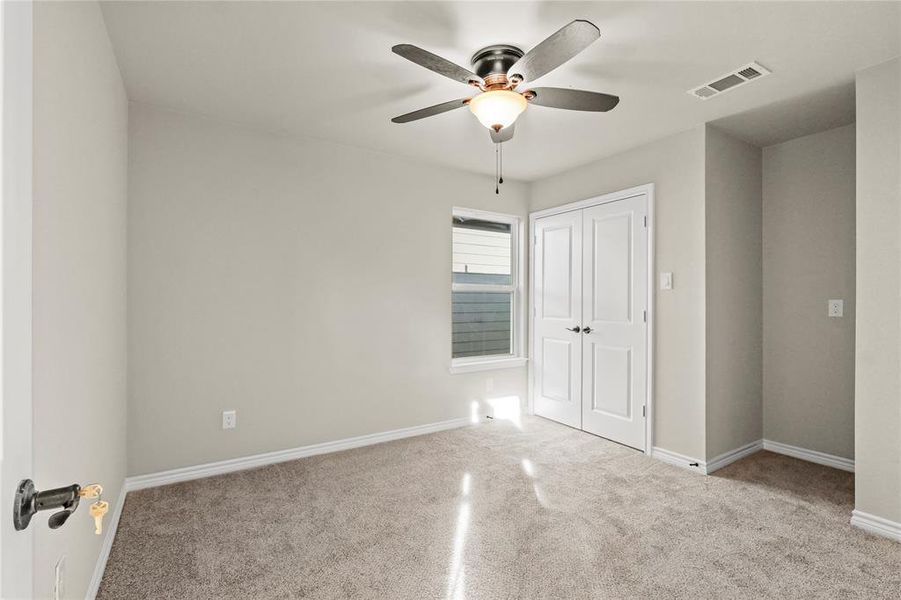 Spare room featuring ceiling fan and light colored carpet