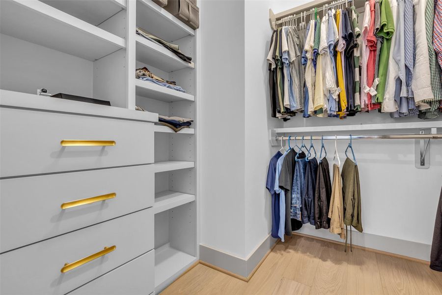 The primary bedroom also includes a walk-in closet with built-in shelves and hanging racks, providing convenient storage and organization for your wardrobe and belongings.