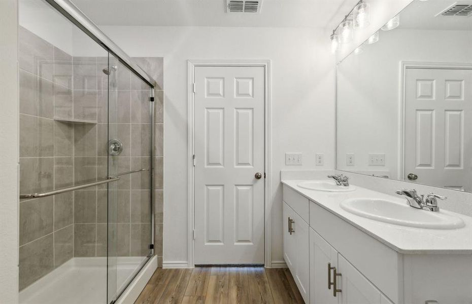 Elegant owner's bathroom with dual vanity and oversized shower*real home pictured