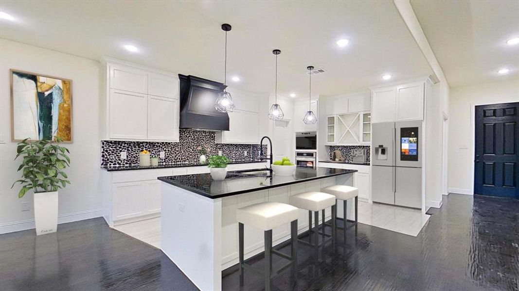 Kitchen with refrigerator with ice dispenser, dark countertops, recessed lighting, light wood-style floors, and an island with sink