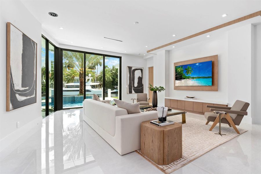 creating the perfect setting for relaxed living and effortless entertaining. Expansive glass doors fill the space with natural light and open to the outdoor area, blending indoor comfort with the beauty of the waterfront.
