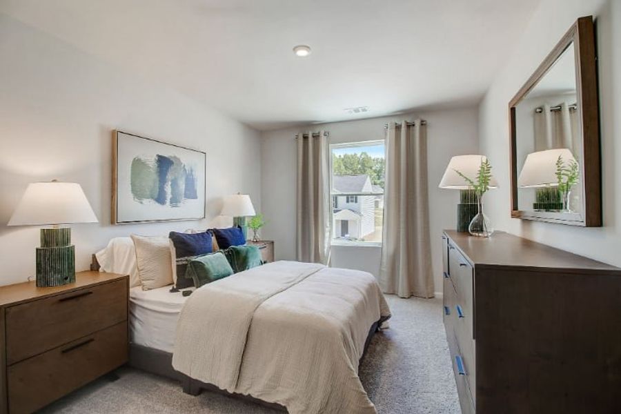 A bedroom with a large mirror.