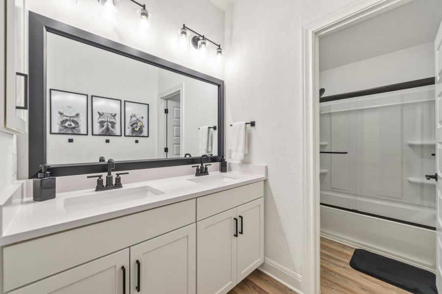 Dual vanity with white shaker-style cabinetry, white quartz countertops, and matte black fixtures