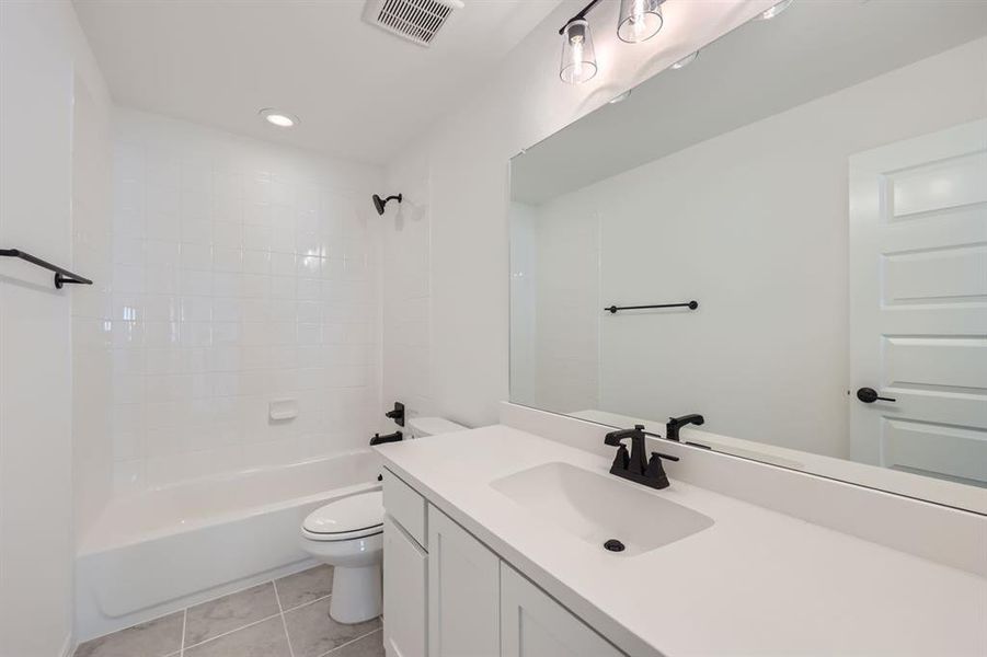 Full bathroom with  shower combination, tile patterned floors, toilet, and vanity