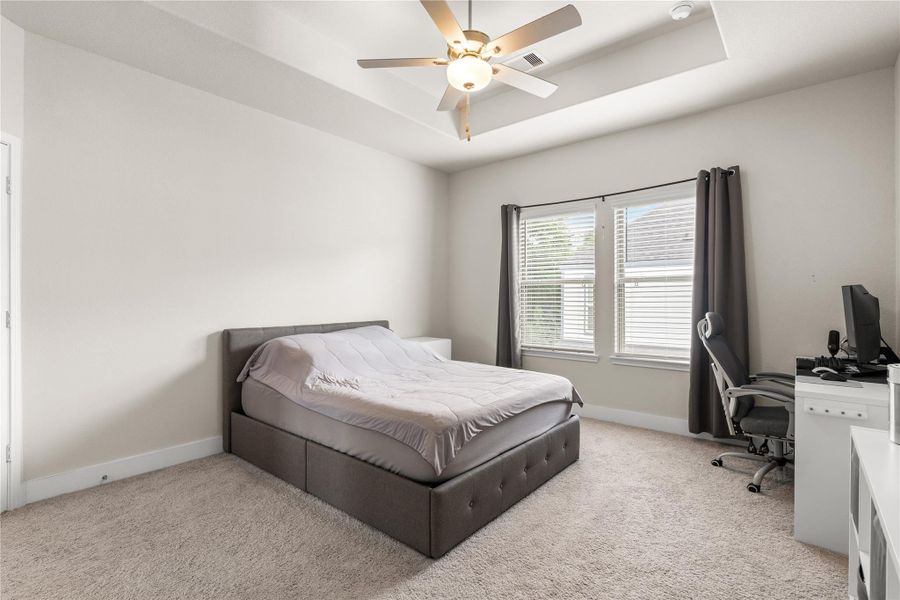 Even with a dedicated workspace and full bedroom furnishings, the primary suite retains a remarkable sense of openness, highlighting the thoughtful proportions of the room.