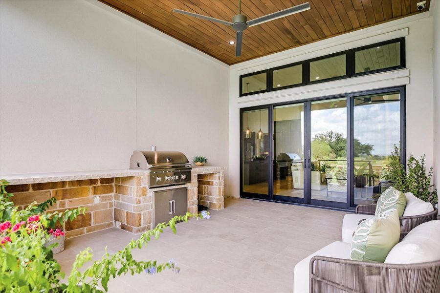 An inviting covered patio featuring an outdoor kitchen and comfortable seating for relaxed al fresco entertaining.