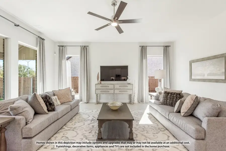 Bright living room with two gray sofas, ceiling fan, coffee table, and sliding glass doors to backyard Bright living room with two gray sofas, ceiling fan, coffee table, and sliding glass doors to backyard