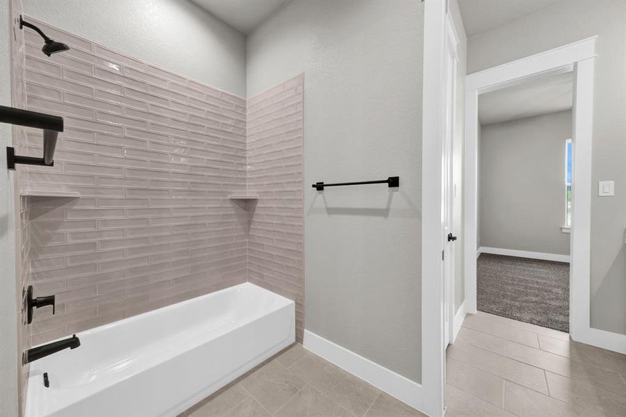 Jack and Jill bathroom with tiled shower / bath and tile flooring