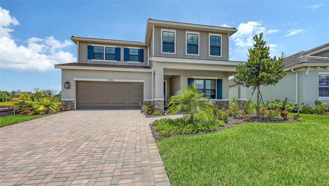 Front exterior of a new home in Palm Grove, Lakewood Ranch, FL, highlighting curb appeal (Image 1). Front exterior of a new home in Palm Grove, Lakewood Ranch, FL, highlighting curb appeal (Image 1).