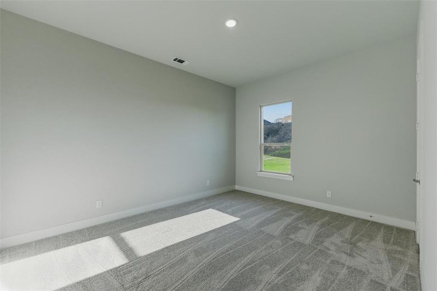Empty room with light colored carpet and a mountain view